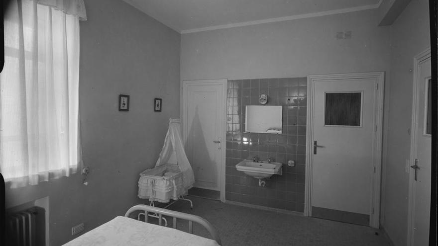 Habitación de maternidad con cama, cuna y lavabo en la Residencia de la Seguridad Social Nuestra Señora del Perpetuo Socorro de Albacete