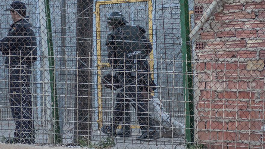 Un agente de la Policía Nacional arrastra a un inmigrante herido al otro lado de la valla de Melilla./ Blasco de Avellaneda