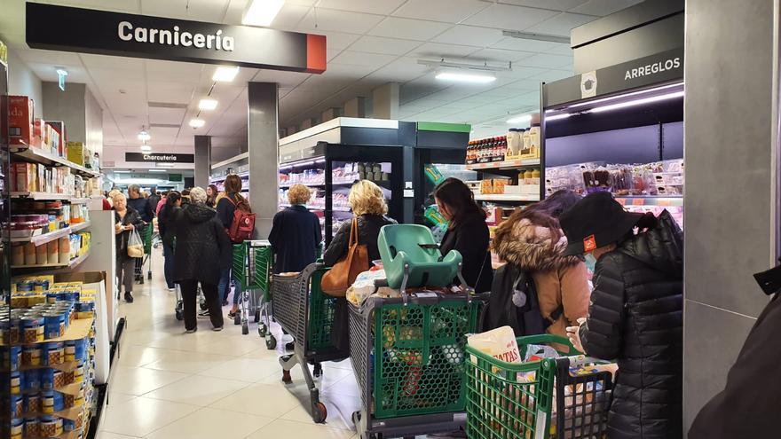  Decenas de personas cargadas de provisiones esperan para poder pagar en un supermercado en Madrid.