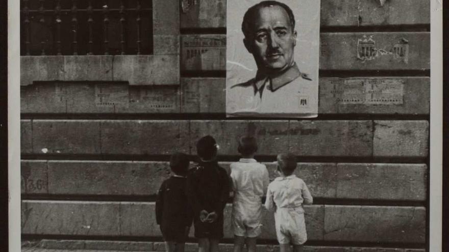 Niños mirando un cartel con la imagen del dictador Francisco Franco.