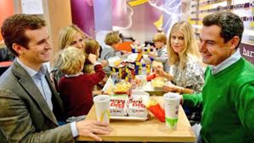 Pablo Casado y Juanma Moreno comiendo con sus respectivas familias en un establecimiento de comida rápida