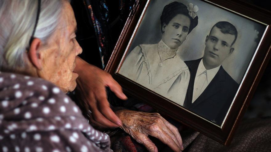 Rosario Peña Luna (84 años), hija de Carmen Luna, ante el retrato de sus padres. | JUAN MIGUEL BAQUERO