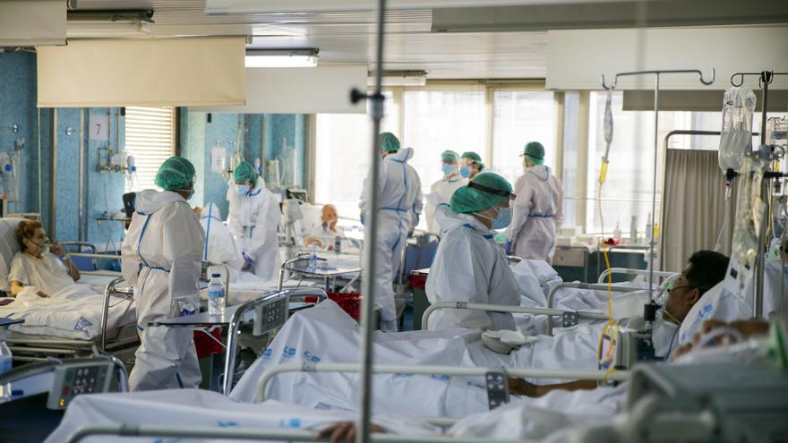 Trabajadores sanitarios atienden a numerosos pacientes en una de las UCI del Hospital Ramón y Cajal de Madrid