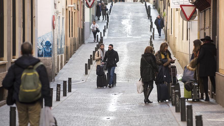 Turistas con maletas por una de las calles del céntrico barrio madrileño de Huertas. / Fernando Sánchez