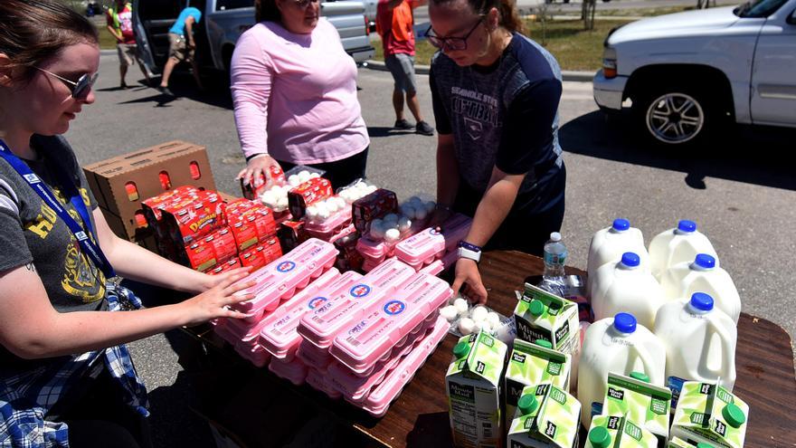 Voluntarias del banco de alimentos Second Harvest de Florida preparan paquetes de huevos, leche y zumos este 3 de abril