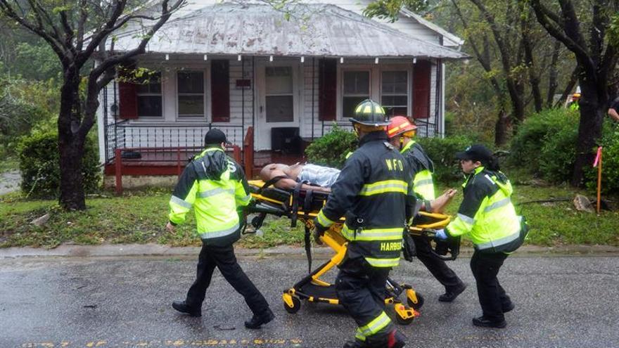Un hombre es atendido después de que un árbol cayera sobre su casa en Wilmington, Carolina del Norte