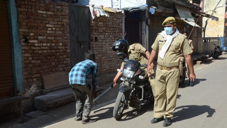 Un policía golpea con un palo a un hombre por saltarse el confinamiento obligatorio impuesto en India.