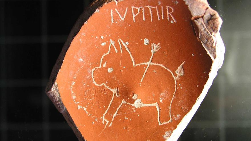 El dibujo de un cerdo con la inscripción "Júpiter", todo ello centrado en una pieza rota