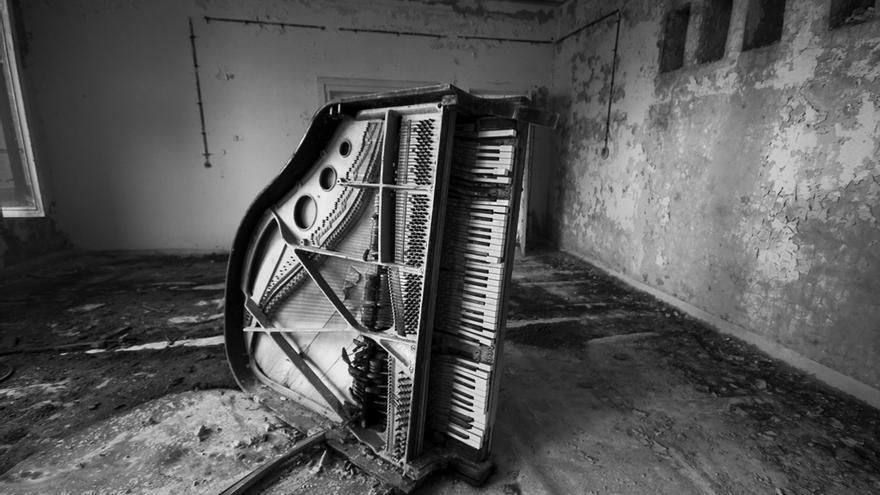 El piano de otra clase de música de la escuela en Prípiat, volcado y con su interior al descubierto