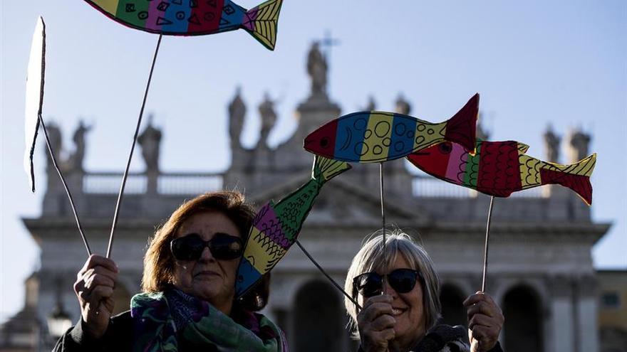 Dos mujeres portan en sus manos pancartas con forma de sardina