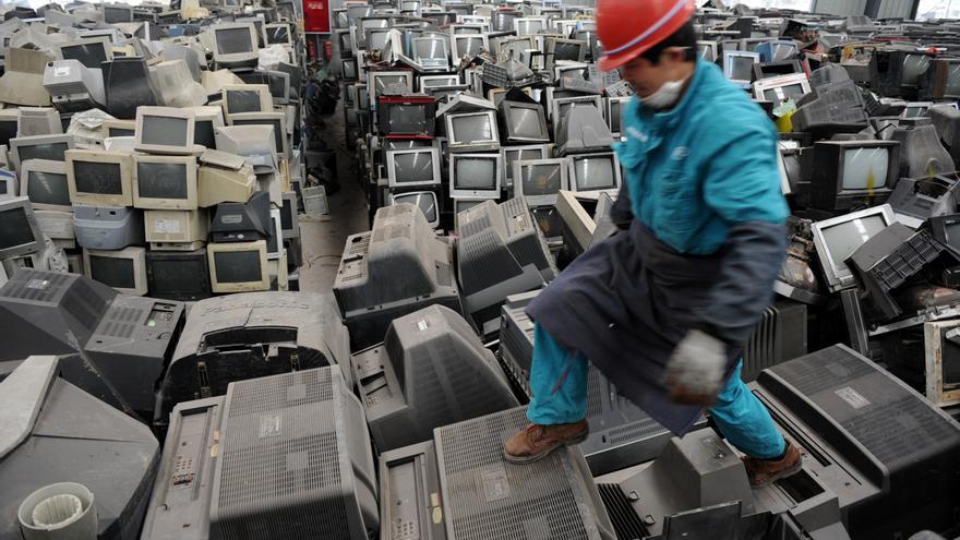 Un trabajador chino camina sobre desechos electrónicos en una planta de reciclaje en la ciudad de Chengdu, en el suroeste del país.