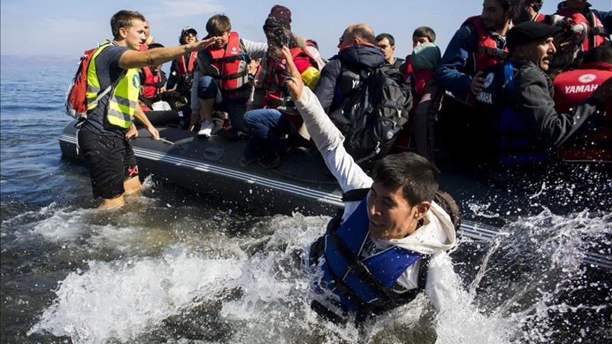 Varias personas saltan de una lancha neumática al llegar a una playa próxima a Skala Sikaminias tras atravesar el Mar Mediterráneo procedentes de Turquía, en la isla de Lesbos (Grecia), a principios de octubre. / EFE