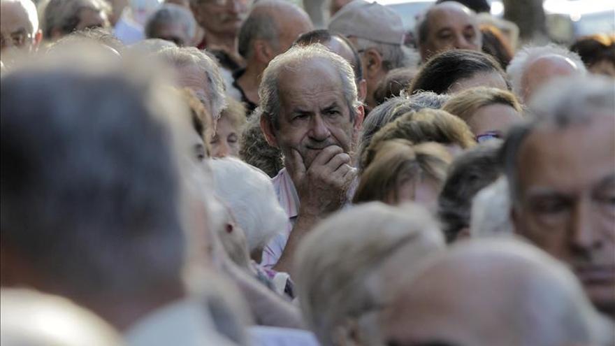 Miles de jubilados griegos hacen colas en los bancos para cobrar parte de sus pensiones
